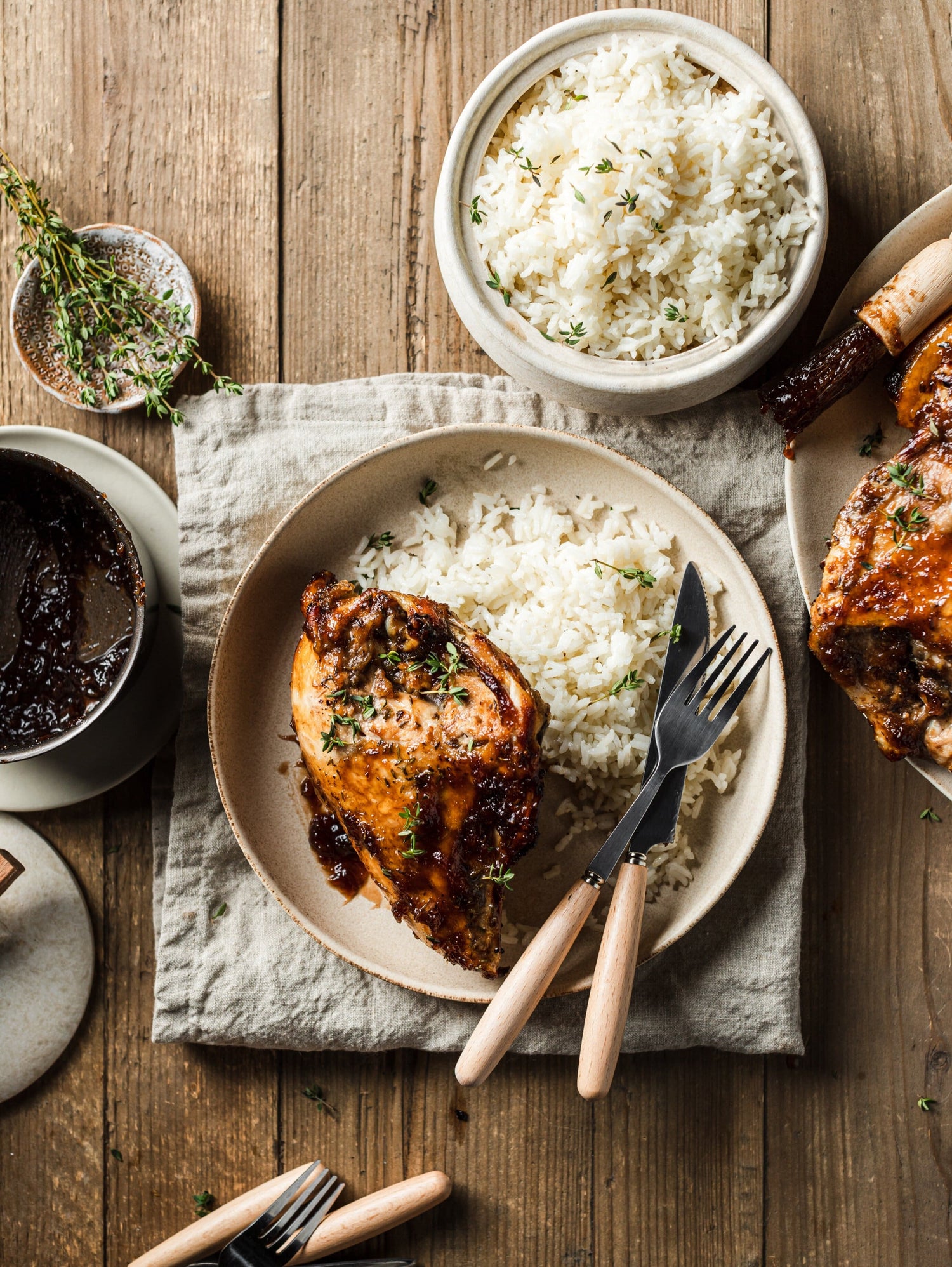 Meal of white rice and a baked chicken thigh with a rhubarb glaze made with Worthy’s Vanilla Rhubarb jam in a rustic setting.