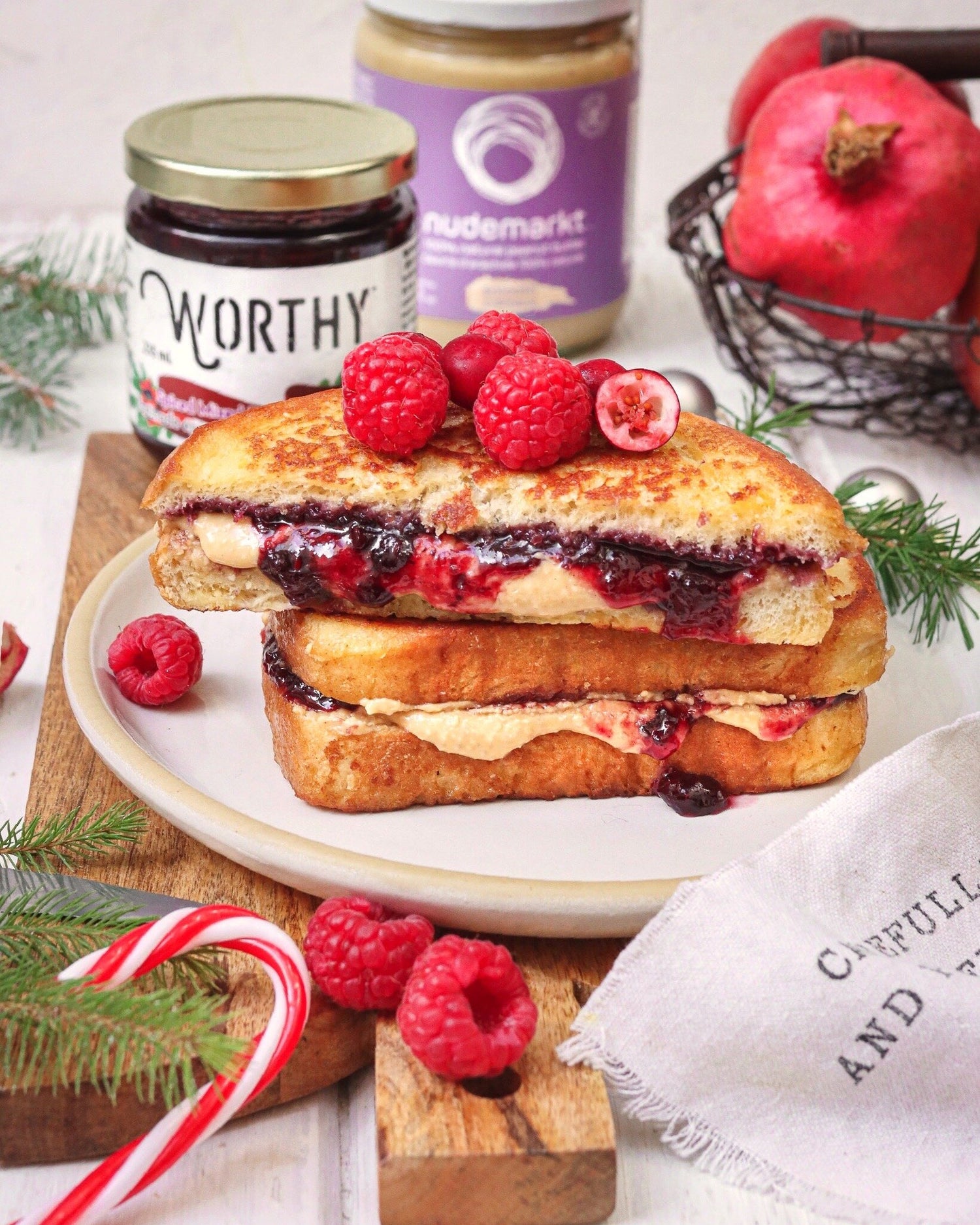 French toast stuffed with Worthy’s Spiced Mixed Berry spread and Nudemarket’s Peanut Butter topped with raspberries in a Christmas setting.