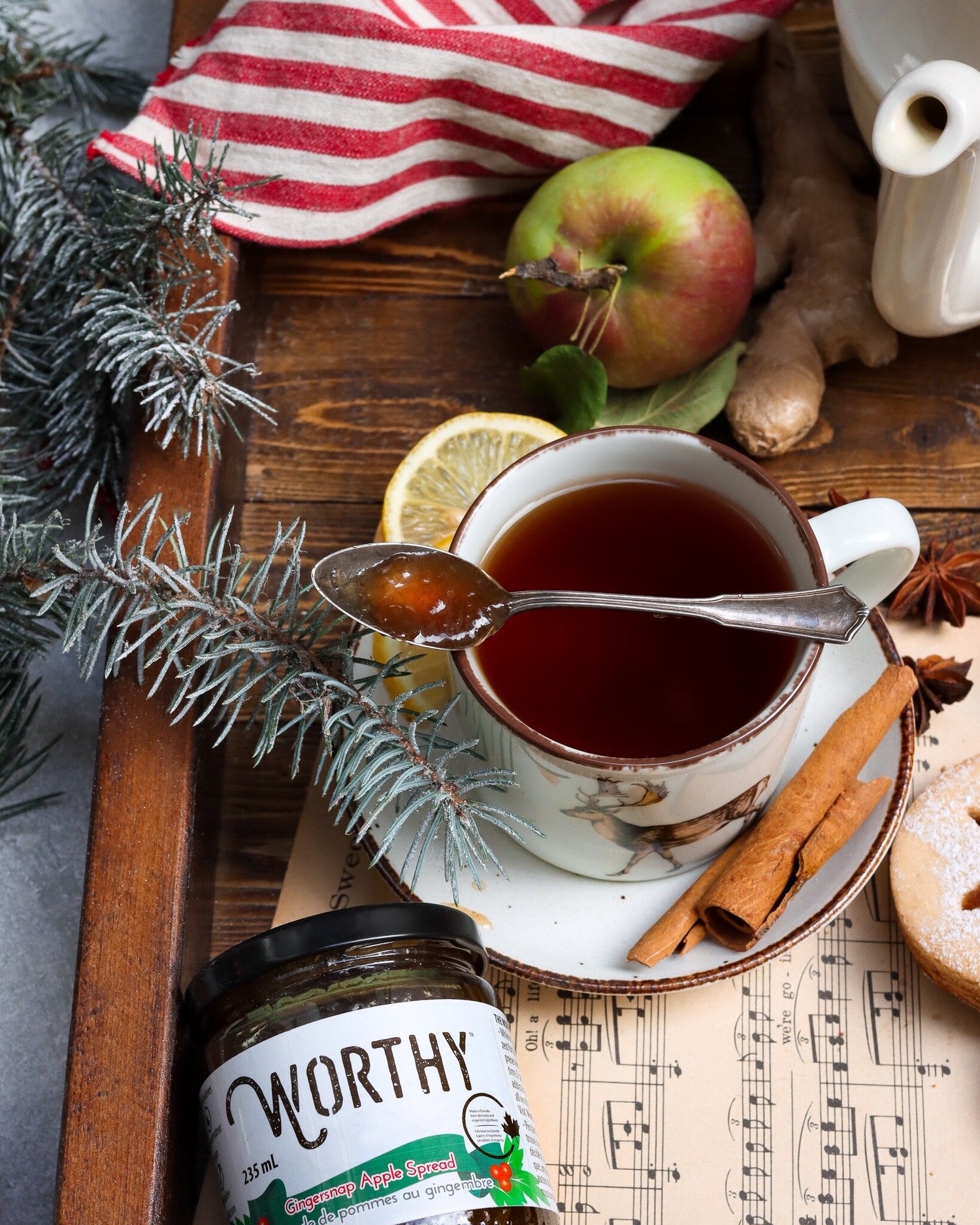 Warm cup of earl grey tea infused with Worthy's Gingersnap Apple Spread in a Christmas setting.