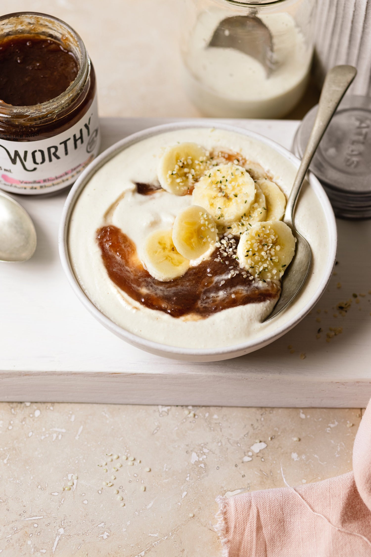 Bowl of blended cashews topped with Worthy’s Vanilla Rhubarb jam, slices of banana and hemp hearts.