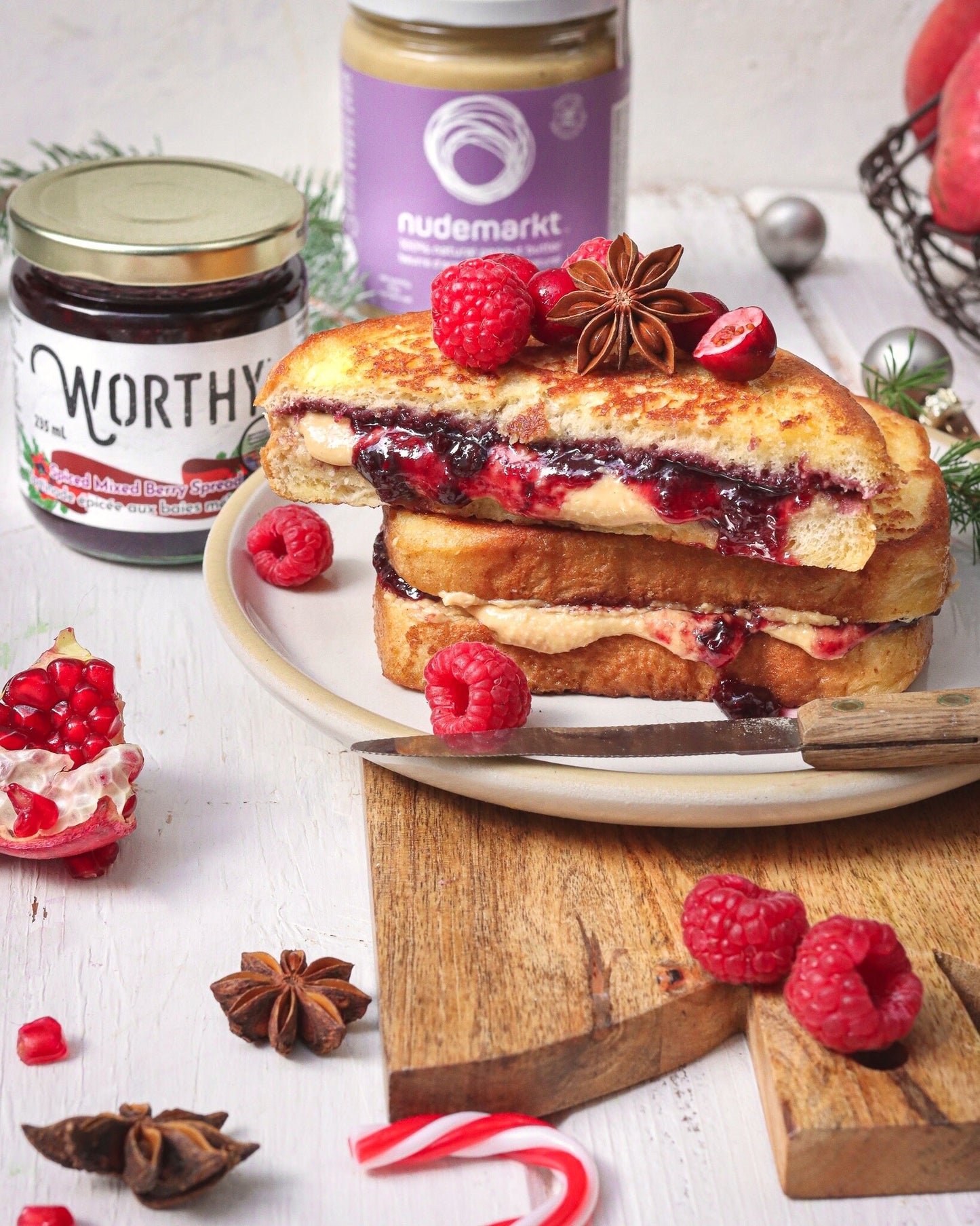 French toast stuffed with Worthy’s Spiced Mixed Berry spread and Nudemarket’s Peanut Butter topped with raspberries in a Christmas setting.
