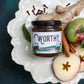  Worthy's Gingersnap Apple Spread displayed on a white plate with fresh ginger, apples, and cinnamon sticks. 