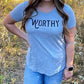 A close up of a grey t-shirt with black "WORTHY" lettering across the front.